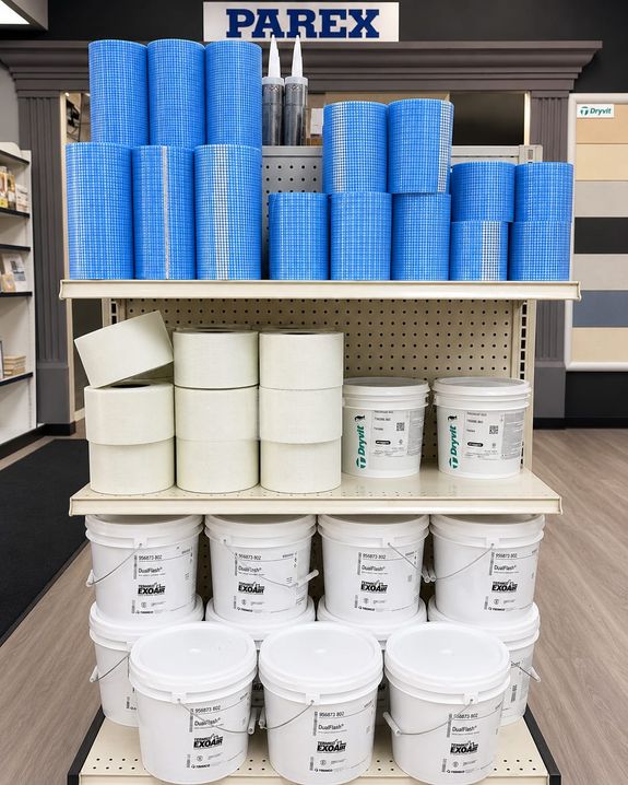 Parex sealants and adhesives display with mesh, Dryvit pails, and EXOAIR products